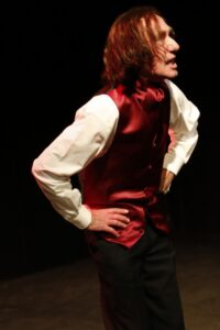Chopin in profile with a hand on his hip, looking off to the side
