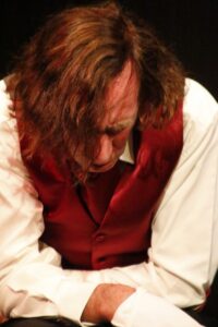 Chopin seated with his head bowed and his hair fallen forward