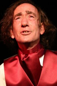 Close-up of Chopin's face in distress, a red cravat at his throat